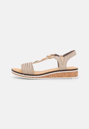 Beige geflochtene Riemensandalette mit Korkkeilsohle, weißer Gummisohle und goldfarbener Hardware-Akzent. Verstellbarer Knöchelriemen.