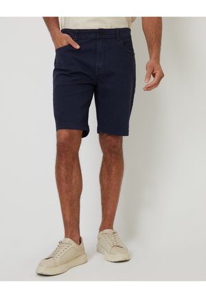 Shorts bleu marine en coton, dotés d'une fermeture à bouton, de poches latérales et d'une coupe droite qui s'arrête juste au-dessus du genou.