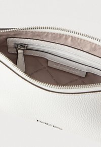 Hvid læderpung med lynlås, tekstureret yderside og beige inderside. Indeholder en lille lynlåslomme og synligt mærkelabel indeni.