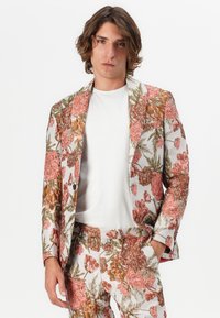 Blomstrete dress i lett stoff med store rosa og oransje blomsterprint, kombinert med en enkel hvit t-skjorte. Strukturert passform med detaljerte lommer.