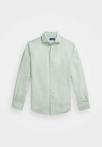 Heleda haljuvaheline helesinine särk, millel on väike valge täpikiri, klassikaline krae, pikad varrukad ja ümar äär.