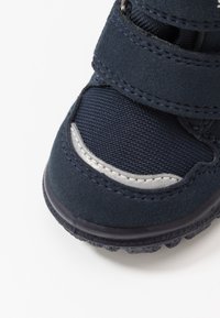 Sneaker blu navy realizzato in tessuto e suede. Caratterizzato da cinturini in Velcro, superficie testurizzata e un accento argento sul lato.