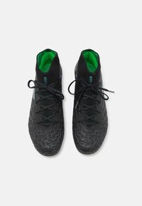 Czarne buty sportowe z teksturowanym wzorem, zielonym wnętrzem i czarnymi sznurówkami. Posiadają opływowy kształt i niską profilację.