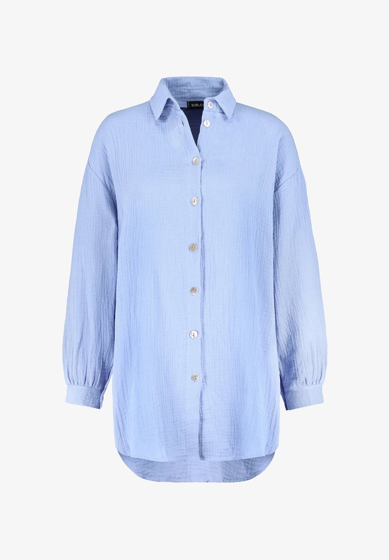 Light blue, button-up shirt made of textured fabric. Features a collar, long sleeves with elastic cuffs, and a rounded hem.