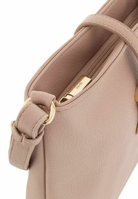 Mała różowa torebka wykonana z teksturowanej skóry, z złotym zamkiem błyskawicznym i okuciem oraz pętlą w detalu pasa do noszenia.