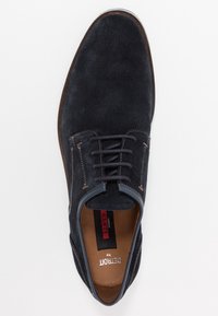 Chaussure en daim bleu foncé avec un bout arrondi, un design à lacets et des surpiqûres contrastées. Elle dispose d'une semelle en cuir marron et d'une semelle intérieure rembourrée.