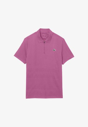 Polo de manga corta color púrpura con un cuello con cremallera y un pequeño logo de cocodrilo verde en el pecho izquierdo.