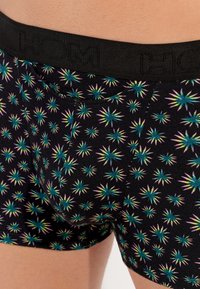 Schwarze Boxershorts mit einem bunten Sternenexplosionsmuster in Türkis und Pink. Mit einem schwarzen elastischen Bund, der das geprägte Markenlogo trägt.