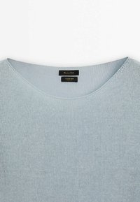 Jasnoniebieski sweter dziergany z okrągłym dekoltem, wykonany z mieszanki bawełny i lnu. Posiada drobną fakturę i minimalne logo przy kołnierzu.