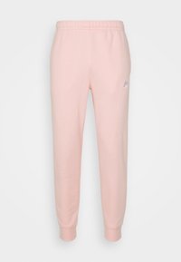 Světle růžové tepláky vyrobené z měkké bavlny, s elastickým pasem a manžetami. Malé fialové logo Nike na levé straně.