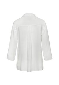 Blouse blanche en tissu léger, avec des manches trois-quarts, un col et un dos droit avec un détail de couture centrale.