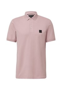 Polo rose en coton respirant, avec un col classique, une patte de boutonnage et un patch logo noir sur la poitrine.