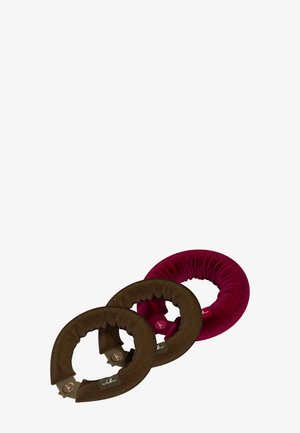 Trois accessoires pour chignon en forme de donut, recouverts de tissu doux, en marron et bordeaux, disposés en diagonale sur un fond blanc.