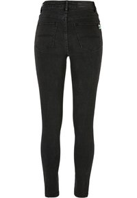 Fekete, skinny farmernadrág, magas derekú, öt zsebes kialakítással és látható varrással. Sima textúrájú, minimális fémalkatrésszel.