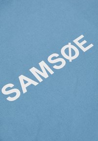 Modrá tkanina s textúrovaným povrchom; obsahuje "SAMSONE" tučnými bielymi písmenami; čistý dizajn bez ďalších vzorov či akcentov.