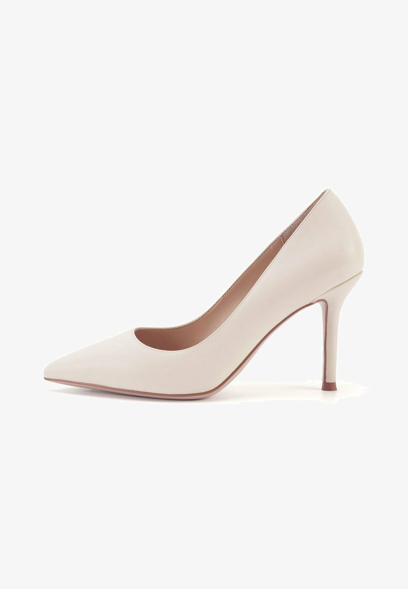 Korkean korokkeen beige nahkakengät, joissa on terävä kärki, avoimet sivut ja kapea stiletto-korko. Sileä pinta ja vähäiset muotoiluyksityiskohdat.