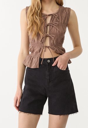 Haut sans manches marron avec texture froncée et nœuds à l'avant, associé à un short en denim noir taille haute avec ourlet effiloché et poches latérales.