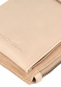 Portafoglio in pelle beige con una texture liscia, dotato di chiusura con zip e logo impresso. Cuciture sottili visibili lungo i bordi.