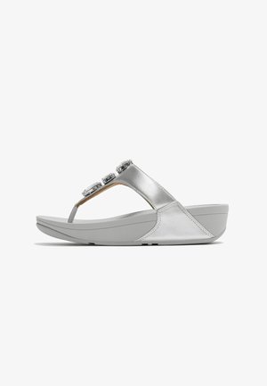 Zilverkleurige sleehak sandaal met comfortabele zool, teenriempje en drie ronde decoratieve versieringen op een witte achtergrond.