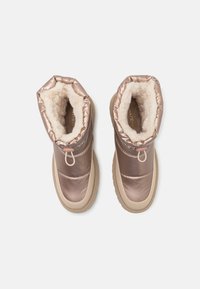Bottines en rose doré métallique avec doublure en fourrure douce et semelles en caoutchouc. Caractéristiques : haut élastique et détails de couture discrets.