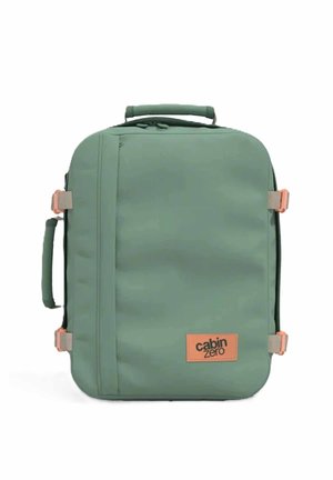 Valigia da cabina morbida rettangolare verde con maniglie superiori e laterali, cinghie di compressione laterali e una toppa con il logo "cabin zero" sul davanti.