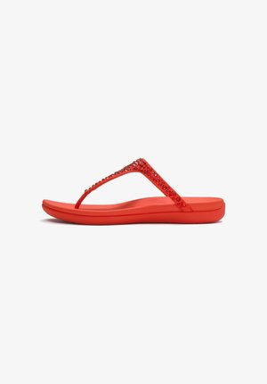 Rode platte flip-flop sandalen met een gevoerde zool en een V-bandje versierd met rode strass steentjes, in zijaanzicht op een witte achtergrond.