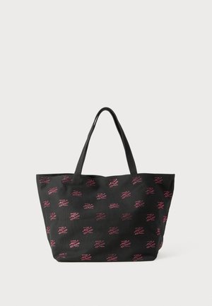 Black fabric tote bag with dual handles and red dotted abstract patterns evenly distributed on the surface against a plain background.