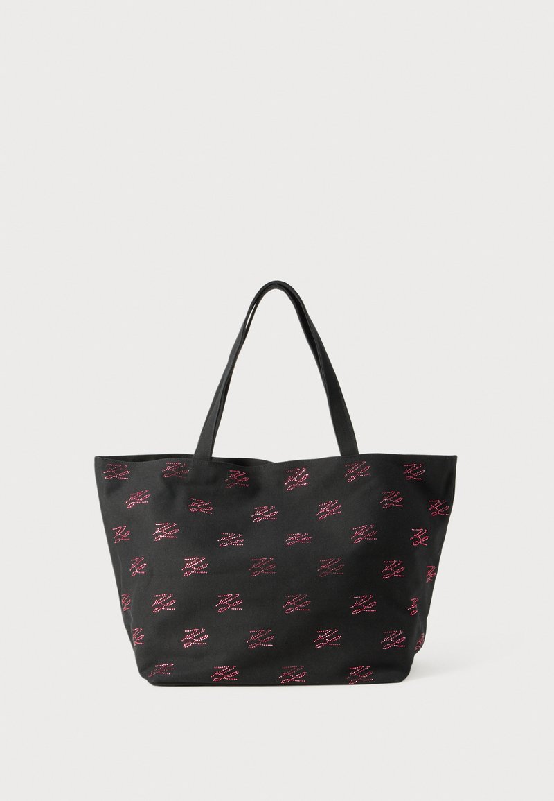 Black fabric tote bag with dual handles and red dotted abstract patterns evenly distributed on the surface against a plain background.