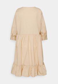 Abito in cotone beige con maniche a tre quarti, collo rotondo e orlo a balze a strati. Tessuto liscio con arricciature sul corpino.