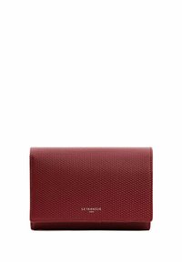 Portefeuille en cuir rouge texturé avec fermeture à rabat, présentant un motif embossé et des détails de logo. Forme rectangulaire compacte, design minimaliste.