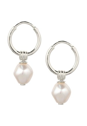 Sølv-hoop øreringe, hver med en enkelt hvid uregelmæssigt formet perle, der hænger fra en tre-ringet connector.