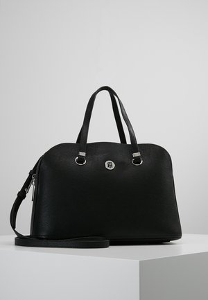 Schwarze strukturierte Lederhandtasche mit zwei oberen Griffen, abnehmbarem Schulterriemen, silbernem Reißverschluss und rundem Metall-Logoemblem auf der Vorderseite.