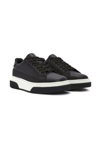 Sneaker in pelle nera con intersuola bianca e suola in gomma nera. Presenta punta tonda, design con lacci e dettagli cuciti.