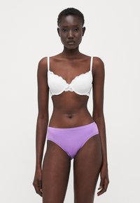 White lace bra with scalloped edges and adjustable straps, paired with lilac cotton briefs featuring lace trim along the waistband.