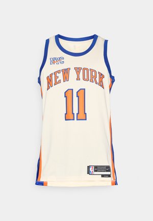 Tricou de baschet New York Knicks în crem, cu accente albastre și portocalii, text mare „NEW YORK”, numărul 11 și branding Nike.
