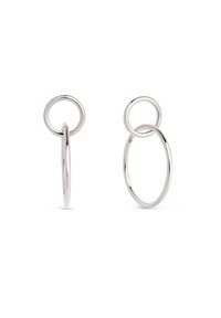 Pendientes de metal plateado con diseños circulares entrelazados, uno ovalado grande y otro círculo más pequeño, con un acabado pulido.