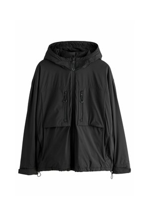 Veste légère noire à capuche avec fermeture éclair à l'avant, deux poches poitrine zippées verticales et cordons de serrage ajustables au bas et aux poignets.