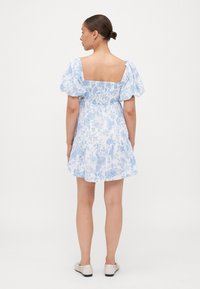 Valge kleit siniste lillemustritega, puhvärviga ja ruudukujulise seljaga. Kerge kangas, liibuv rinnaosa ja kihiline seelik. Kandmiseks kerged jalanõud.