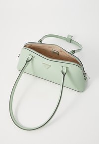 Mint green leather handbag with a structured shape, dual handles, zipper closure, and interior featuring a patterned lining and a logo tag.