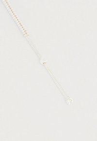 Sidabrinė karoliukų apyrankė su dvigubo grandinėlės dizainu ir ovaliais akcentais, suapvalintu užsegimu su logotipu ir tekstūruotomis grandinėlėmis.