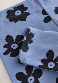 Pamut anyag világoskék alapon, nagy fekete virágmintákkal. Látható varrásokkal és feltekert szegéllyel.