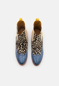 Botas de cano curto em pele, com uma biqueira azul com perfurações, parte superior com estampado de leopardo e um tab na parte traseira amarelo para fácil calçar.