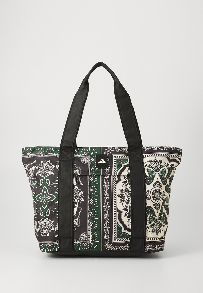 Tote bag with black straps, featuring a floral pattern in green, white, and black, made of durable fabric, with a structured rectangular shape.