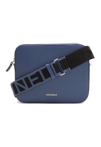 Modrá kožená kabelka přes rameno obdélníkového tvaru s texturovaným povrchem, černo-modrým pruhovaným popruhem a zlatým logem.