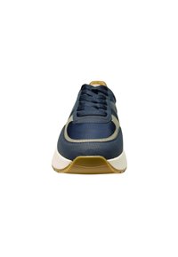 Marineblaue Sneaker mit einem glatten Leder-Obermaterial, kontrastierenden beigen Akzenten, sechs Ösen und einer weißen Zwischensohle, ausgestattet mit einer strukturierten Gummi-Außensohle.