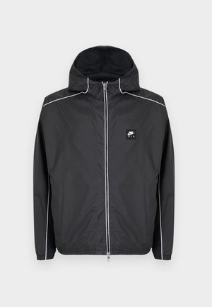 Čierna mikina Nike Air na zips s kapucňou a bielym lemovaním na rukávoch, ramenách a zipsu, vybavená elastickými manžetami a spodným lemom.