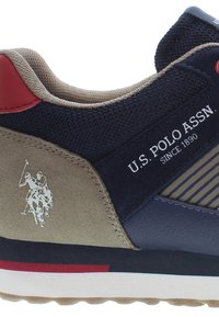 Zapatillas para hombres con parte superior de malla en azul marino, acentos en ante beige, diseño a rayas, tirador en el talón rojo y un logo de jugador de polo.