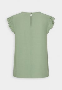 Zielona bluzka z falbaniastymi rękawami, z tylnym zapięciem w kształcie łezki i gładką fakturą. Prosty, nieozdobiony fason oraz prosty dół.