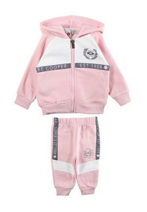 Ensemble de survêtement en coton rose comprenant un sweat à capuche zippé avec des accents blancs et un logo, accompagné d'un pantalon de survêtement assorti avec des bandes latérales.