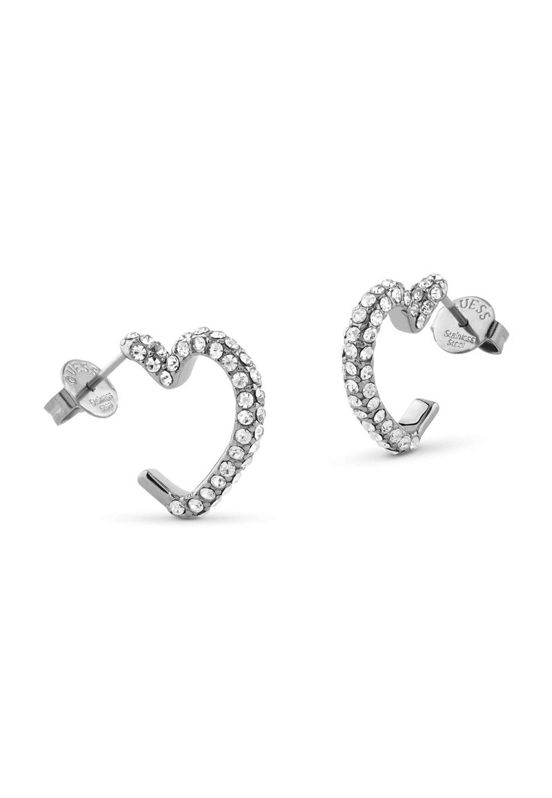 Boucles d'oreilles en forme de cœur en argent ornées de strass transparents, avec un design légèrement tordu et un fermoir à clou pour un port sécurisé.